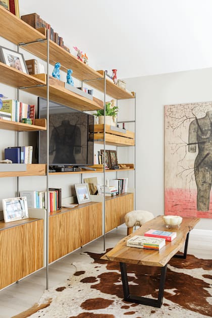 El cuadro del rosarino Daniel García que acompaña a Graqce desde hace 20 años alude al resurgir. Sillón y mesa baja (Filipponi Deco).