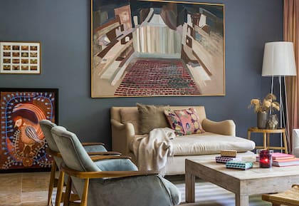 El cuadro sobre el sillón fue un regalo de casamiento y es de la artista Luciana Levinton (Diderot). “Es del Teatro Colón, cuando lo vi me enamoré. Fue nuestra primera obra importante.” A la izquierda, sobre el piso, una de las pocas obras propias que Abril exhibe en su casa.