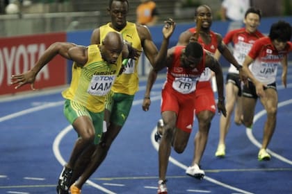 El cuarteto caribeño dominó la carrera; acá, Bolt le pasa el testimonio a Powell
