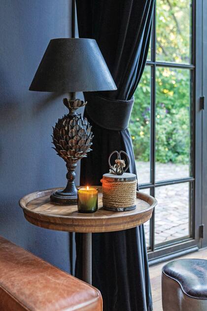 El cuero de los sillones y la madera se despprenden del entorno azul marino y suman calidez.