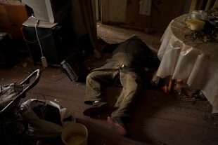 El cuerpo de un hombre yace en un apartamento mientras continúan los bombardeos rusos en un pueblo recientemente retomado por las fuerzas ucranianas cerca de Kharkiv, Ucrania, el sábado 30 de abril de 2022.