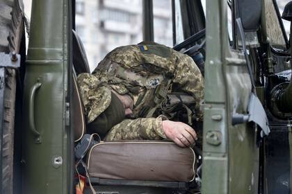 El cuerpo de un militar ruso que vestía uniforme de servicio ucraniano yace dentro de un vehículo después de que él y otros miembros de un grupo de asalto recibieron disparos durante un enfrentamiento en la capital ucraniana de Kiev