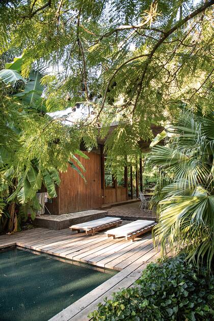 El deck es de tablones de lapacho antiguo y el color verde petróleo del agua provocado por las piezas de vidrio esmaltadas le da ese aspecto que se conjuga con el entorno