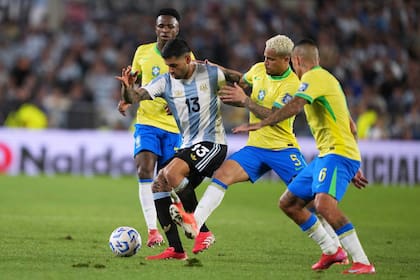 El defensor de Argentina, Cristian Romero, disputa la pelota con Joao Gomes (5) y Guilherme Arana (6) de Brasil durante un partido por las eliminatorias sudamericanas para el Mundial 2026 en Buenos Aires, Argentina, martes 25 marzo, 2025. (AP Foto/Natacha Pisarenko)