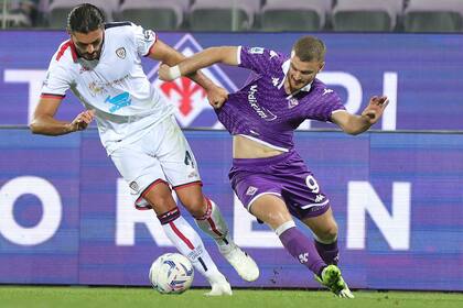 El defensor Dossena sujeta de la camiseta a Beltrán en un ataque de Fiorentina