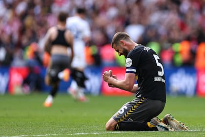 El defensor Jack Stephens se arrodilla y celebra el ascenso de Southampton a la Premier League