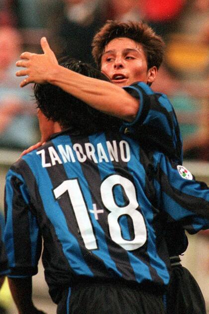 El delantero chileno del Inter, Iván Zamorano, de espaldas a la cámara, es abrazado por su compañero de equipo Javier Zanetti de Argentina después de anotar durante el partido de la Copa de Italia contra el Cesena en el estadio de Milán San Siro el miércoles 9 de septiembre de 1998. Zamorano agregó un signo más "nostálgico". su no. 18, después de que su número nueve fuera entregado al as brasileño Ronaldo para la temporada 1998/99. Inter ganó 1-0.