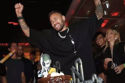 El delantero, feliz, con las dos tortas que hubo en el festejo. Una tenía una imagen del futbolista caracterizado mitad Batman, mitad Guasón, como un cuadro que tiene en su casa.