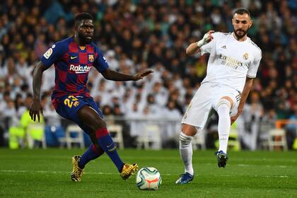 El delantero francés del Real Madrid Karim Benzema (R) desafía al defensor francés del Barcelona Samuel Umtiti durante el partido de fútbol de la Liga española entre el Real Madrid y el Barcelona en el estadio Santiago Bernabeu en Madrid el 1 de marzo de 2020