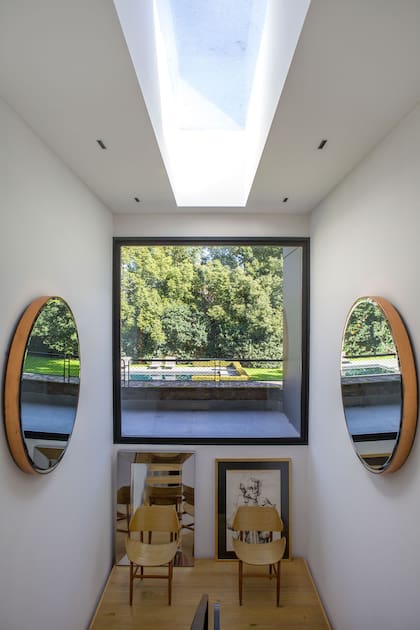 El descanso se ambientó con espejos enfrentados y un dúo de sillas (Santiago del Campo)