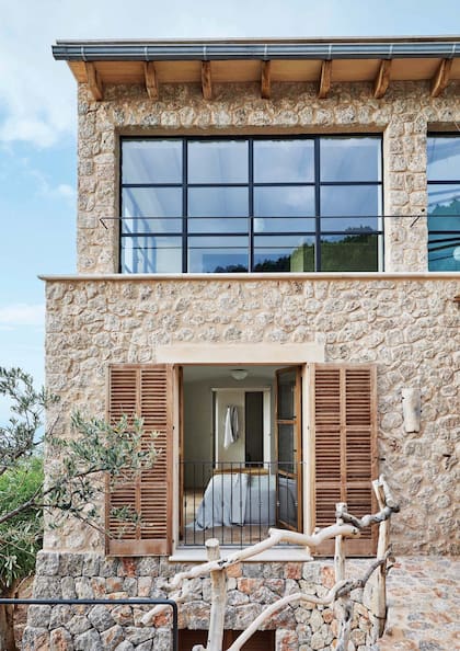 El detalle de la baranda hecha en ramas irregulares le da un encanto único a la escalera del ingreso.