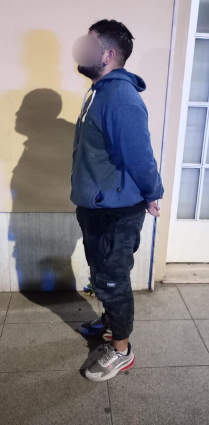 El detenido, esposado frente a la vivienda donde fue encontrado tras ingresar por los techos para robar plantas de marihuana