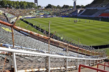 El deterioro de los alambrados de frente; de fondo, el estadio y el público que fue a ver el primer partido del campeonato