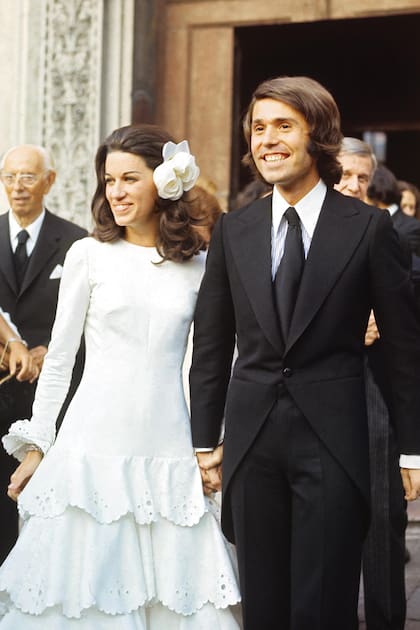 El día de su boda, cuando salen de la iglesia de San Zacarías en Venecia, tras la ceremonia religiosa. La novia lució un traje confeccionado en piqué blanco con volados y completó su look nupcial con una flor de organza en su cabeza.