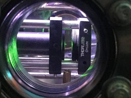 El diminuto punto verde en el centro de la imagen es un nanodiamante (aproximadamente 0,00000004 m) que levita en vacío gracias a la acción de un láser infrarrojo focalizado (pinzas ópticas). Experimento llevado a cabo por A. C. Frangeskou, A. T. M. A. Rahman, L. Gines, S. Mandal, O. A. Williams, P. F. Barker y G. W. Morley.