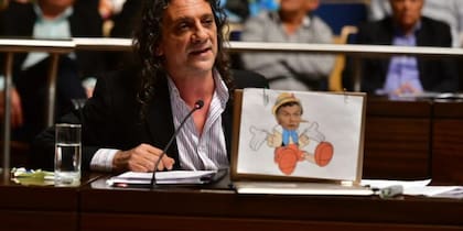 El diputado Martín Sereno en su banca, con una caricatura de Mauricio Macri