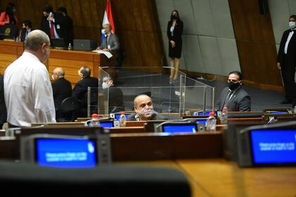 El diputado paraguayo Basilio Núñez se sienta dentro de una caja transparente alrededor de su escritorio, que instaló como medida preventiva en medio de la propagación del coronavirus, durante una sesión en el Congreso en Asunción, el 17 de junio de 2020