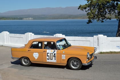 El dique de La Florida tiene un pintoresco puente de barandas blancas y sierras de fondo; por allí avanza el Peugeot 404 de Miguel Gómez Fernández y Cristian Fernández, vencedores generales por quinta vez.