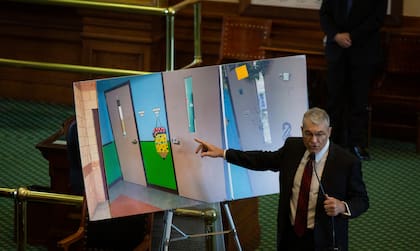 El director del Departamento de Seguridad Pública de Texas, Steve McCraw, utiliza fotos de puertas para presentar lo que sucedió durante el tiroteo en la escuela primaria Robb en Uvalde, Texas, ante el Comité Especial del Senado de Texas, el martes 21 de junio de 2022. 