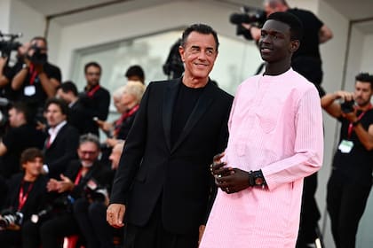 El director italiano Matteo Garrone, ganador del León de Plata, junto al actor Seydou Sarr, que recibió el premio al Actor Revelación por el film Io Capitano