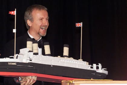 El director James Cameron ríe mientras acepta un modelo del Titanic en una ceremonia en Nueva York, en 1998, un año después del estreno de su película