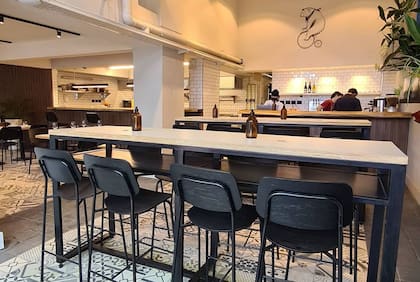 El discreto salón con la cocina integrada mediante una barra de despacho marca el ritmo del servicio en un ambiente relajado