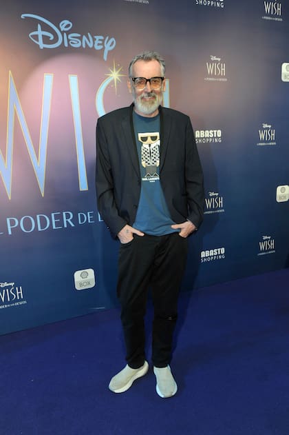 El diseñador Benito Fernández, de elegante sport: pantalón y saco negro, zapatillas y remera azul con estampa