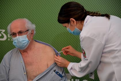 El doctor Almir Ferreira de Andrade, de 79 años, recibiendo la vacuna