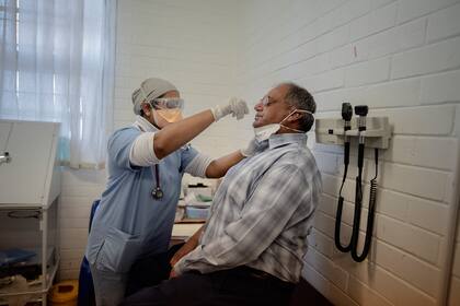 El doctor Aslam Dasoo recibe un hisopado en la Unidad de Investigación de Patógenos Respiratorios y Meníngeos (RMPRU) en el Hospital Chris Hani Baragwanath en Soweto el 14 de julio de 2020