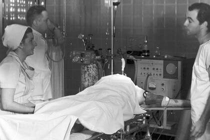 El doctor Martín Rodríguez y dos ayudantes se preparan para operar a Emilio Tomasetti; la foto en la que se encuentran sin barbijos, generó polémicas