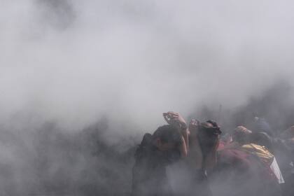 Los manifestantes se cubren de los gases que arrojan los carabineros durante las protestas
