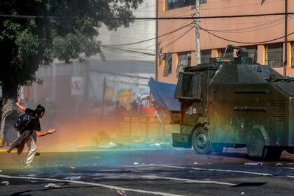 Un joven arroja piedras a un camión hidrante