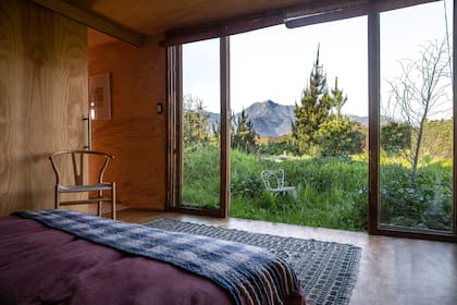 El dormitorio principal con una alfombra traída de un viaje a Italia y una silla Danesa parte de la colección de Tololo.