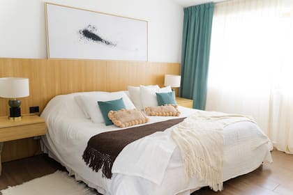 El dormitorio principal invita a la calma: Manta de telar en lana de oveja y almohadones rectangulares con pompones de Casa Clara (@casaclara_bsas). Obra de arte de Pared (@pared.art), lámparas de Salazar Casa (@salazarcasa