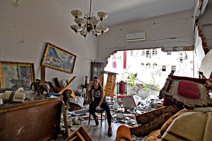 Una mujer sentada entre los escombros de su casa dañada en la capital libanesa, Beirut