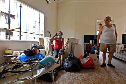 Una pareja trata de limpiar los escombros en su hogar