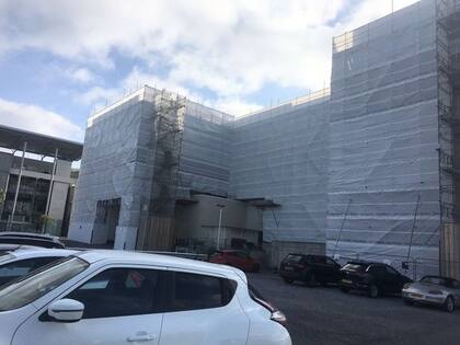 El edificio cubierto de andamios y de una red de seguridad