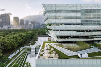 El edificio está tallado y retorcido para reflejar el parque y el cielo circundantes, revestido continuamente con una fachada de vidrio transparente.