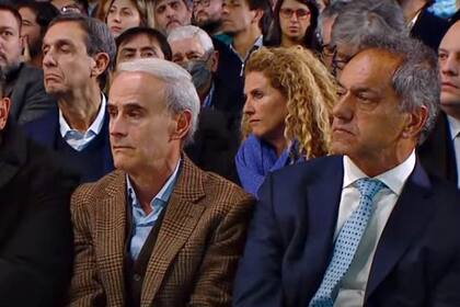 El embajador Daniel Scioli sentado junto a Julio Vitobello, secretario general de la Presidencia, en el acto por los 100 años de YPF