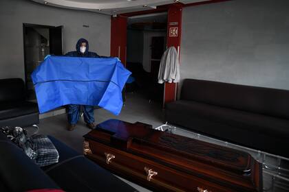 El empleado mexicano de la funeraria Antonio Padilla muestra cómo se desinfectan las bolsas y se usan para transportar a las víctimas del nuevo coronavirus en Ciudad Nezahualcóyotl, estado de México, México, el 7 de mayo de 2020