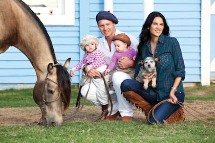 El empresario posa con sus mujeres. En brazos de Gaby, uno de los cachorritos que viven en la chacra