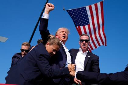 El entonces candidato republicano a la presidencia Donald Trump es protegido por agentes del Servicio Secreto en un atentado en su contra durante un acto de campaña el 13 de julio de 2024, en Butler, Pensilvania