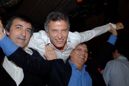 El entonces ministro de Educación porteño, Esteban Bullrich, y Gianfranco Macri levantaron a Mauricio por el aire.
