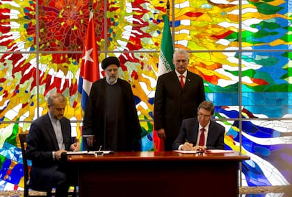 El entonces presidente iraní, Ebrahim Raisi, izquierda, y el presidente cubano, Miguel Díaz-Canel, de pie junto a sus respectivos ministros de Relaciones Exteriores, en la firma de acuerdos bilaterales durante su visita en La Habana, Cuba, el jueves 15 de junio de 2023.