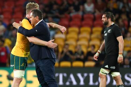 El entrenador de los Wallabies, el neocelandés Dave Rennie, se abraza con el segunda línea Matt Philip tras la victoria ante All Blacks, su primera al frente del seleccionado australiano. Lo sufre Sam Whitelock.
