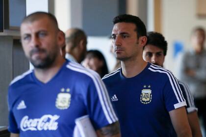 Scaloni camina detrás de Walter Samuel, uno de sus asistentes en el cuerpo técnico. El entrenador vive horas difíciles.