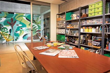 El equipamiento del taller es simple y funcional: una mesa laqueada con caballetes de hierro, sillas ‘Tolix’ (Prestigio) y estantería metálica (Mercado Libre).