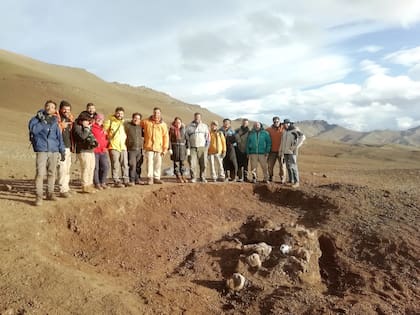 El equipo de científicos argentinos y japoneses junto al hallazago en el sitio de Estancia Anita.