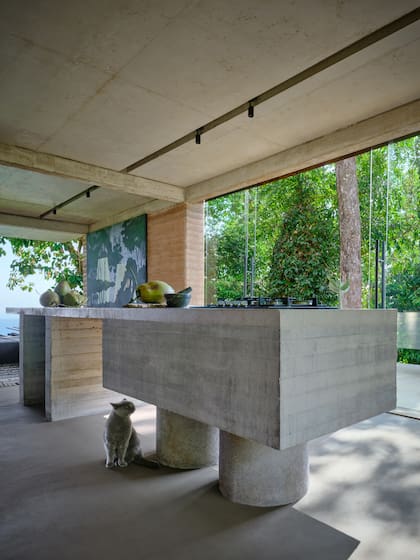 El espacio de estar del nivel superior se concibe como un gran ambiente único, anclado por una isla de cocina de hormigón de cuatro metros de largo.