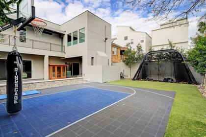 El espacio exterior incluye pileta, jacuzzi, galería techada con chimenea y una cancha de básquet privada dentro de un entorno cerrado